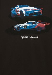 Camiseta negra con dos coches de carreras estilizados en azul y rojo con el número "1", sobre un logotipo blanco de BMW M Motorsport.