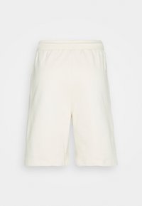 Shorts crème clair, longueur genou, en coton doux, avec une taille élastique et sans poches ni ornements visibles.