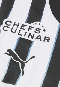 Črno-bela športna majica z navpičnimi črtami, logotipom "CHEFS CULINAR" in črnim logotipom Puma na levi strani.