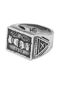 Anello in argento con una parte superiore rettangolare decorata con la scritta in rilievo "LE COSE BELLE DURANO" e due mani giunte, lati testurizzati con accenti triangolari.