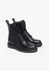 Schwarze Leder-Ankle-Boots mit glatter Oberfläche, Schnürung an der Vorderseite, abgerundeter Zehenpartie und einer niedrigen, strukturierten Gummisohle. Mit Zuglaschen an der Rückseite.