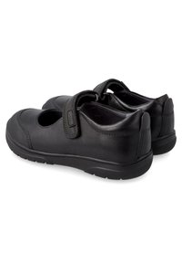 Zapatos de cuero negro con puntera redonda, diseño perforado y tira de velcro ajustable. Presentan una suela de goma texturizada para garantizar agarre.