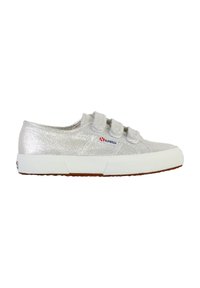 Zapatilla deportiva de purpurina plateada con suela de goma blanca. Presenta dos correas de tipo velcro, upper texturizado y un parche de marca en el lateral.