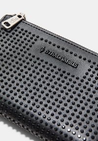 Černá zipová taška s texturovaným povrchem pokrytým malými černými hroty a kovovou nášivkou se nápisem "STRADIVARIUS".