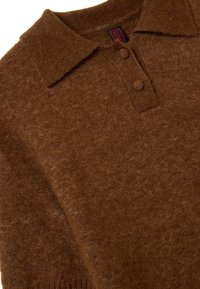 Pullover marrone lavorato a maglia con colletto polo, due bottoni e una texture morbida. Presenta un delicato motivo melange e polsini a costine.