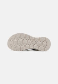 Sola di una sneaker, realizzata in materiale gommoso testurizzato di colore bianco con un motivo di forme esagonali e ovali per una migliore aderenza.