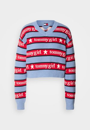 Crop pullover-genser i blå med røde og svarte stiper. Har repeterende "tommygirl"-tekst og stjerne motiver. Strukturert strikket stoff.