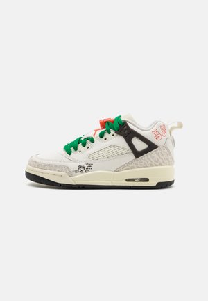 Sneaker bianca con lacci verdi, dettagli grigi e suola nera. Presenta pannelli in rete, stampa grafica e un dettaglio arancione brillante sulla linguetta.