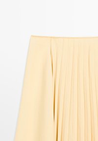 Lichtgeel geplooid stof met een gladde textuur, met verticale plooien. De bovenkant heeft een schone, verzamelde uitstraling.