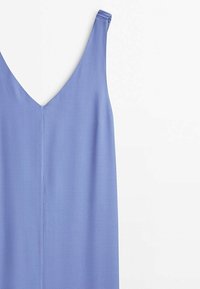 Robe sans manches bleu clair avec un décolleté en V et des bretelles fines légèrement froncées sur fond blanc.