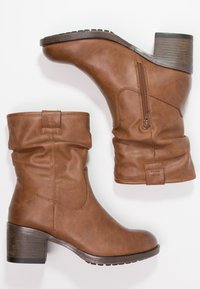 Bottines en simili cuir marron avec un talon carré, un dessus souple, une fermeture éclair sur le côté et une semelle texturée pour une meilleure adhérence.
