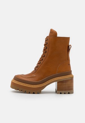 Brown leather lace-up ankle boot with chunky block heel and rugged sole on a white background, side view.