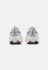 Baskets de course grises avec une tige en maille texturée, présentant des accents bleu foncé et une semelle blanche avec des détails de talon violets, orange et noirs.