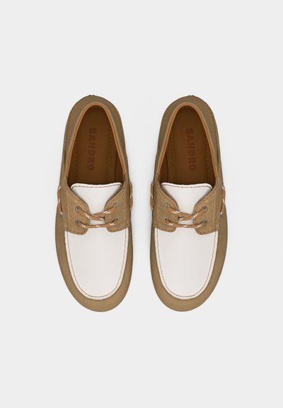 Ζευγάρι από καφέ και λευκά δερμάτινα παπούτσια για βάρκα με λεπτομέρειες κορδονιών, σε άποψη από πάνω σε απλό φόντο.