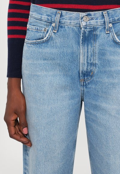Light blue denim jeans featuring five pockets, a button fly, and a classic straight-leg cut. Visible stitching and fading details.
