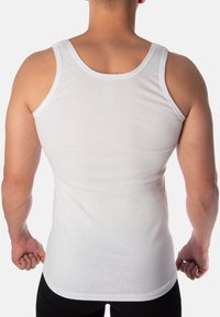 White cotton tank top with wide straps and a fitted cut, showing smooth texture and clean lines, viewed from the back.