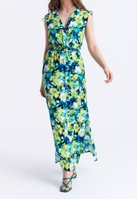 Kukallinen maksimekko sinisenä ja vihreänä. Siinä on V-pääntie, lyhyet hihat nauhoilla ja elastinen vyötärö. Kevyt kangas, jossa on virtaava muotoilu.