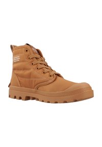 Botte montante en tan faite de matériau synthétique lisse, dotée d'un col rembourré, d'une semelle en caoutchouc et d'un design de laçage prominent.