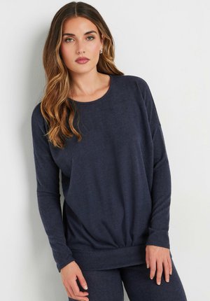 Pull au col rond en tissu texturé doux, de couleur bleu marine, avec des manches longues. Il possède un ourlet froncé pour un ajustement décontracté.