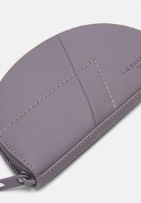 Lila Lederbörse in runder Form, mit sichtbaren Nähten und einem Reißverschluss. Minimalistisches Design ohne zusätzliche Muster.