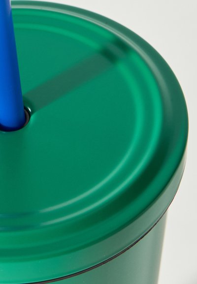 Πράσινο πλαστικό ποτήρι με προσαρμοσμένο καπάκι και μπλε επαναχρησιμοποιήσιμο καλαμάκι που έχει τοποθετηθεί μέσω της κεντρικής τρύπας του καπακιού.