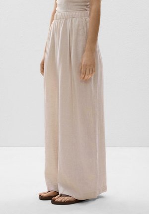 Lyse beige bukser med vide ben lavet af et blødt stof med en tekstureret finish, der har elastik i taljen og folder for en afslappet pasform.