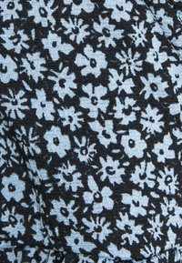 Černá látka s hustým vzorem malých světle modrých květin, s jemně vroubkovanou strukturou a kontrastními květinovými motivy po celé ploše.