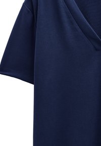 Granatowa koszulka w serek wykonana z miękkiej bawełny, z krótkimi rękawami, o gładkiej strukturze z minimalną liczbą szwów i bez widocznego wzoru.