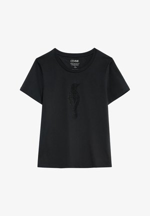 Czarna koszulka z krótkim rękawem i okrągłym dekoltem, z subtelnym, błyszczącym wzorem sylwetki ptaka umieszczonym centralnie na piersi.