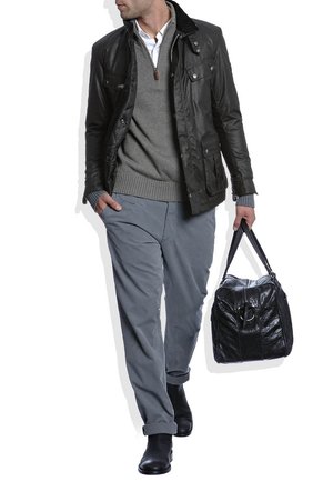 Zwart leren jack, grijze trui, lichtgrijze broek en zwarte laarzen. De persoon draagt een gestructureerde zwarte tas met handvaten.