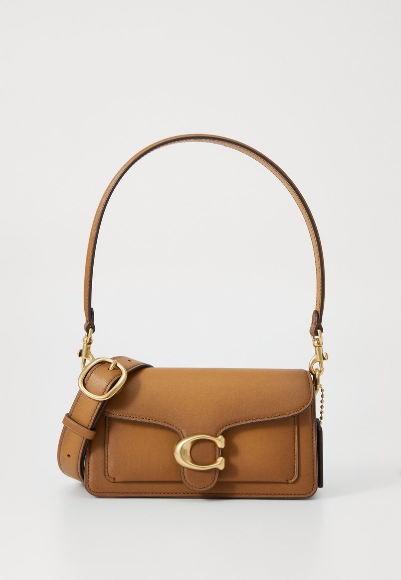 Brown leather handbag with a curved shoulder strap, gold hardware, and a magnetic flap closure. Features a front pocket and stitched detailing.