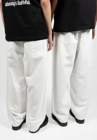 Wasted Paris CASPER PANT UNLEASHED UNISEX - Platūs džinsai - off white