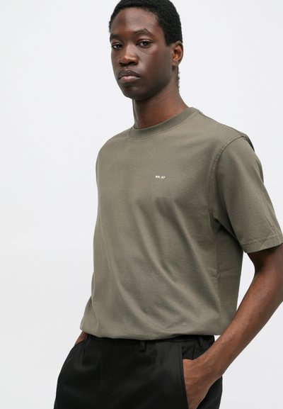 T-shirt in cotone verde oliva con collo a girocollo a coste e maniche corte, caratterizzato da un piccolo logo bianco "NN. 07" sul petto.
