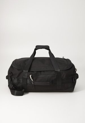 Musta kankainen duffelikassi, jossa on teksturoitu pinta, kaksinkertaiset kahvat, irrotettava olkahihna ja etuosassa vetoketjullinen tasku säilytystä varten.