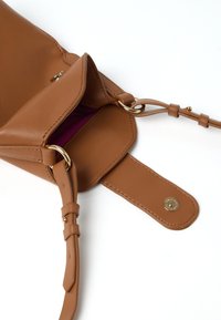 Borsa in pelle color cammello con un design compatto, dotata di chiusura a scatto dorata, manico regolabile e rivestimento interno viola.