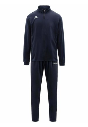 Tuta Kappa blu navy con giacca con zip integrale e pantaloni abbinati, con logo Kappa bianco sul petto e sulla coscia sinistra.