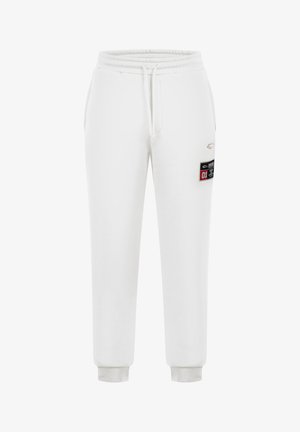 Pantaloni della tuta bianchi realizzati in un morbido misto cotone, con vita elasticizzata e cordoncino, gambe affusolate e una tasca laterale.