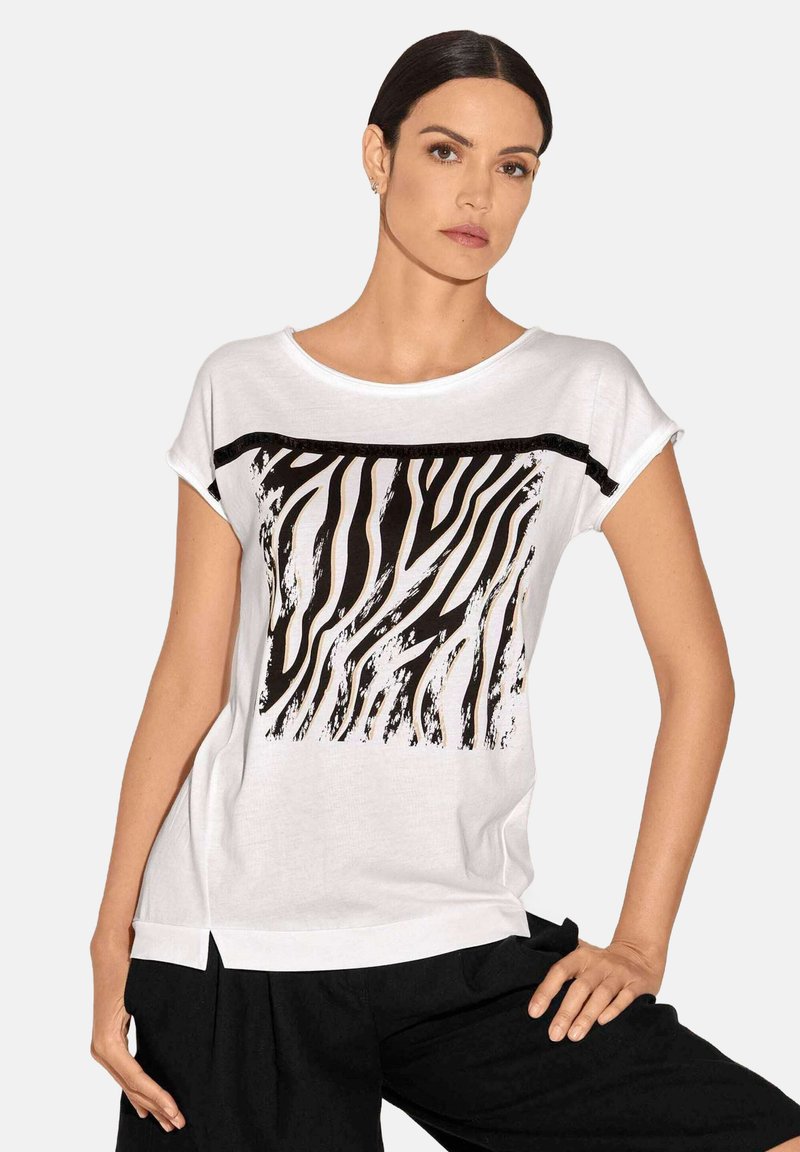 Weißes T-Shirt mit kurzen Ärmeln, das ein schwarz-weißes Zebra-Streifen-Design über der Brust aufweist, mit einem abgerundeten Halsausschnitt und seitlichen Schlitzen.