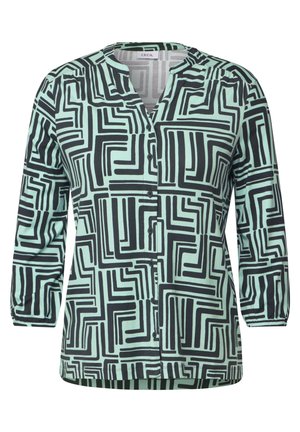 Langarmshirt in mintgroene katoen met een zwart geometrisch patroon, met een V-hals en knoopsluiting aan de voorkant. Zachte textuur, relaxte pasvorm.