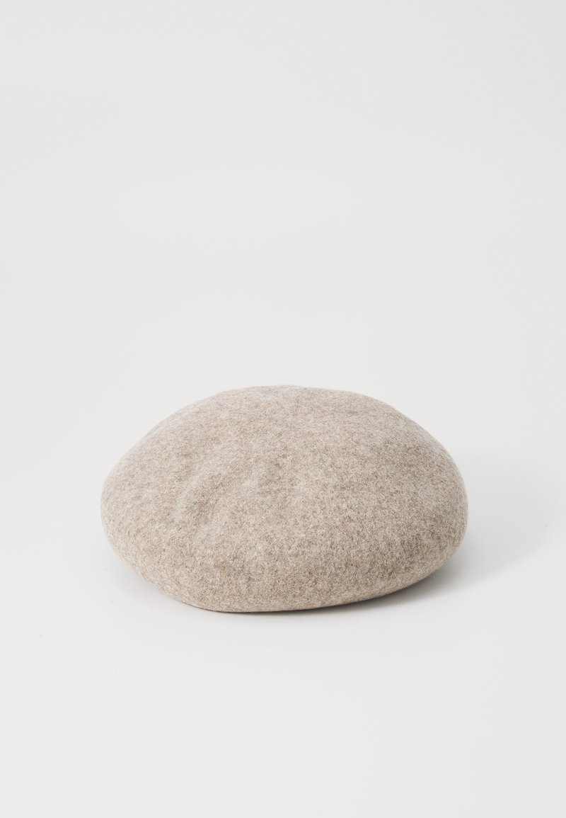 Beige Filzberet mit einer runden, weichen Form, der eine glatte Textur hat und keine sichtbaren Verzierungen aufweist. Ideal für verschiedene Stile.