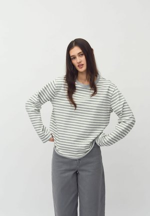Striped pullover in light gray and white, made of soft fabric. Long sleeves, crew neck, and a relaxed fit. Paired with gray wide-leg pants.