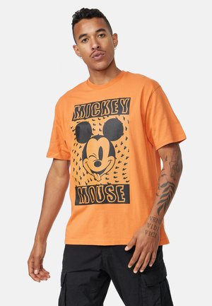 Camiseta de algodón naranja con un gráfico de Mickey Mouse en negro, mangas cortas, escote redondo y dobladillo recto.
