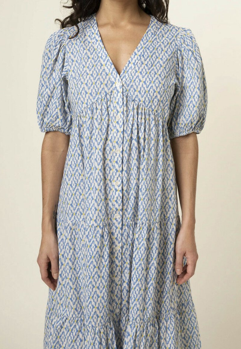 Blue and white patterned dress with short puff sleeves, V-neckline, button-down front, and gathered waist detail. Features a tiered skirt.