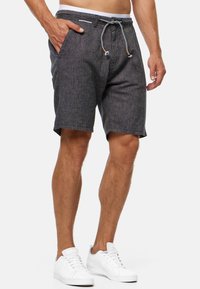 Donkergrijze shorts voor heren, gemaakt van een gestructureerde stof, met een elastische tailleband met zwart-witte accenten en voorkruiszakken.