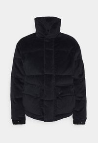 Giacca puffer in corduroy nero con colletto alto. Presenta cuciture orizzontali, due tasche frontali e bottoni a pressione ai polsini.