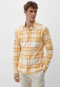 Gelb-weiße karierte Hemd mit langen Ärmeln, einem Knopfkragen und einer einzelnen Brusttasche. Strukturierter Stoff mit kontrastierenden orangefarbenen Linien.