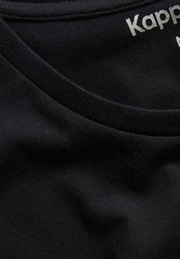 Svart bomullströja med rund halsringning och en mjuk textur. Den inre kragen visar "Kappa"-logotypen i silver.