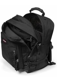 Sort Eastpak rygsæk med flere rum, lynlåse, mesh sidelomme og et topbærehandtag. Holdbart stof med en struktureret overflade.
