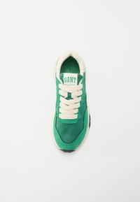 Green athletic sneaker featuring suede and nylon materials, beige laces, and a white sole. Includes a branded tongue label.