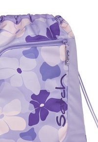 Purple drawstring bag featuring floral patterns in lighter and darker shades, with a zippered pocket and brand label. Made of durable fabric.